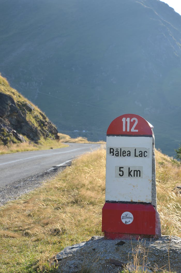 Scenic route to Bâlea Lac with milepost in the foreground, surrounded by mountain scenery.